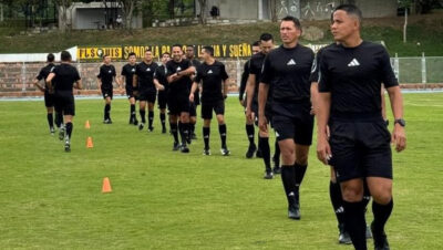 Grupo de árbitros colombianos trotando en una sesión de entrenamiento con conos